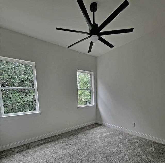 empty room featuring carpet floors, ceiling fan, and baseboards