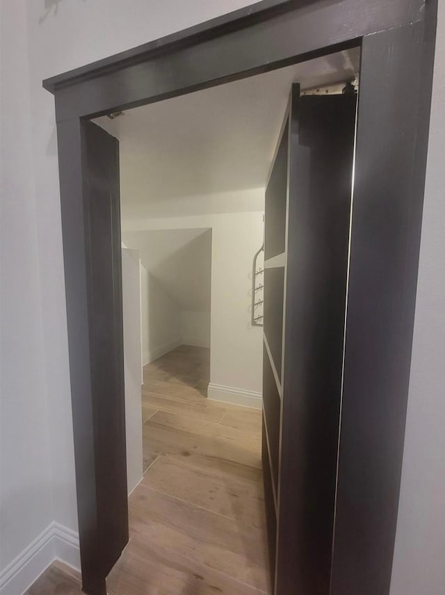 hallway with light wood finished floors and baseboards