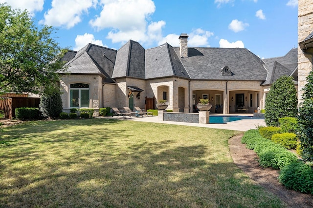 6615 Bluffview Dr, Frisco, TX 75034 - back of property featuring a patio, a chimney, stone siding, and a yard