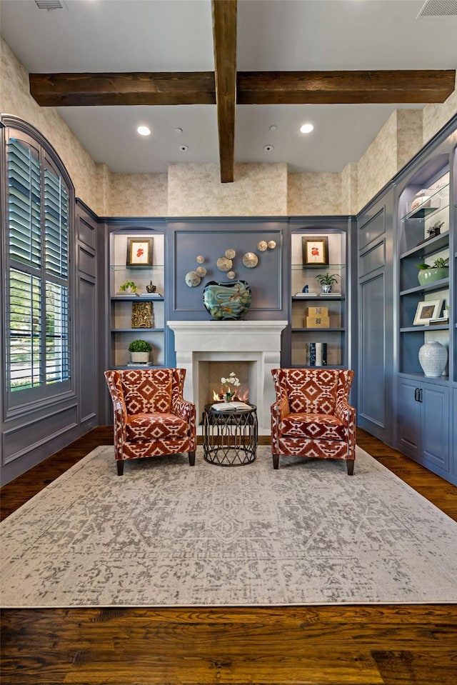 6615 Bluffview Dr, Frisco, TX 75034 - sitting room featuring built in shelves, dark wood finished floors, beam ceiling, recessed lighting, and a lit fireplace