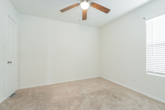 carpeted spare room with baseboards and ceiling fan