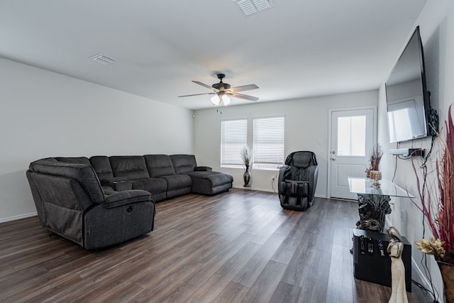 living area featuring dark wood-type flooring, a ceiling fan, and visible vents