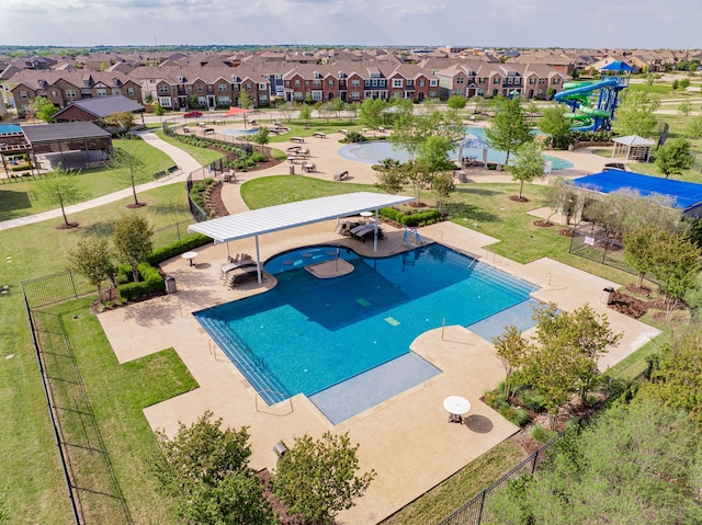 view of pool featuring fence, a residential view, and a water slide