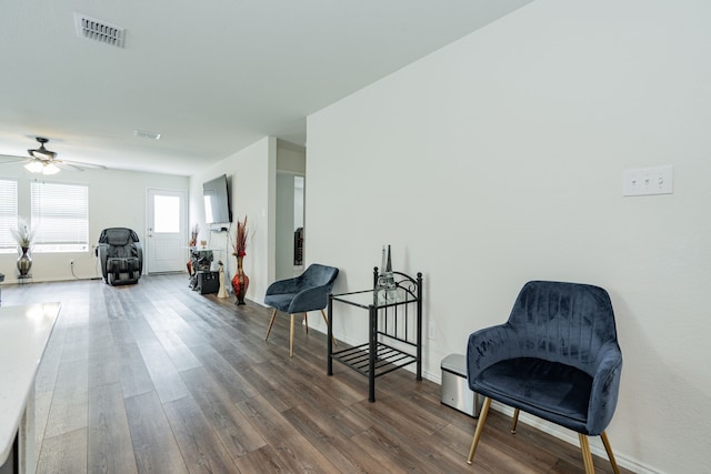 sitting room with visible vents, ceiling fan, wood finished floors, and baseboards