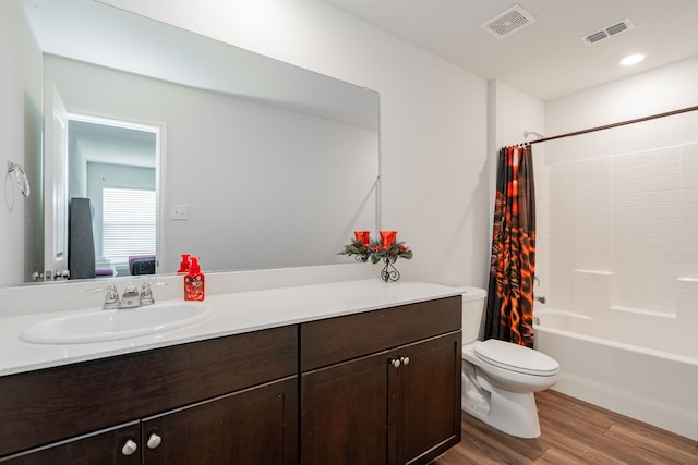 ensuite bathroom with vanity, visible vents, toilet, and wood finished floors