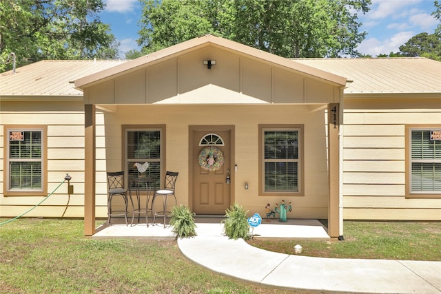 411 Johnson St, Longview, TX 75602 - view of front of house featuring metal roof, a front yard, and covered porch
