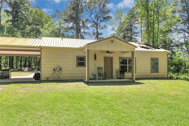 411 Johnson St, Longview, TX 75602 - back of property with ceiling fan, a lawn, metal roof, and a patio area