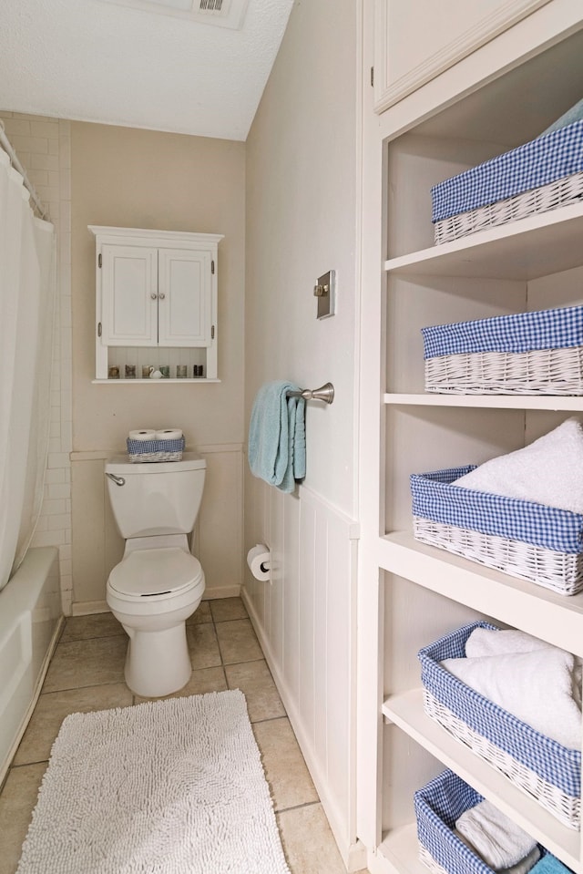 full bathroom featuring tile patterned floors and toilet