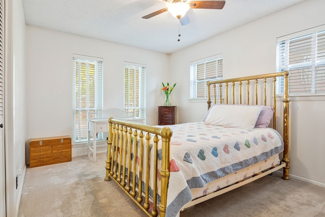 carpeted bedroom featuring baseboards and ceiling fan