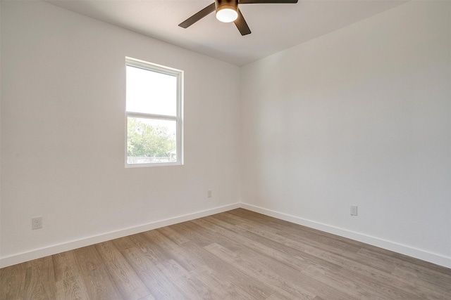 empty room featuring a ceiling fan, baseboards, and light wood-style flooring