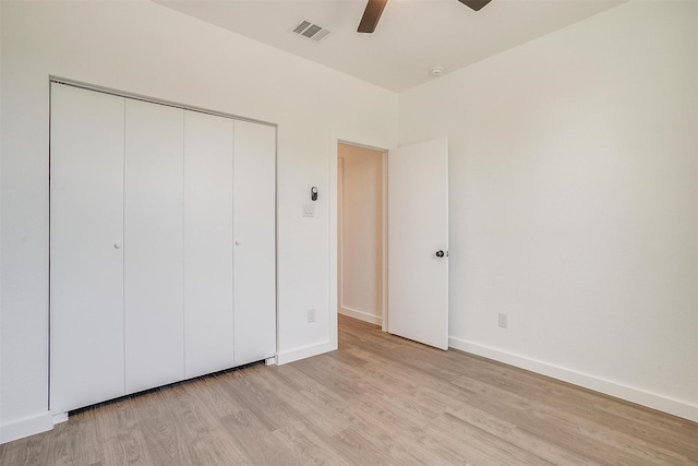 unfurnished bedroom featuring baseboards, a closet, light wood finished floors, and visible vents