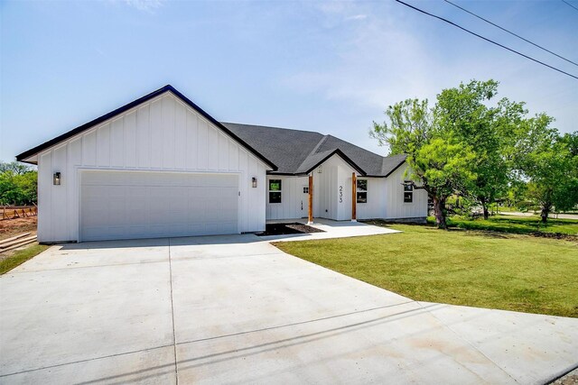 233 Lakeshore Dr, Runaway Bay, TX 76426 - modern inspired farmhouse with board and batten siding, concrete driveway, an attached garage, and a front yard