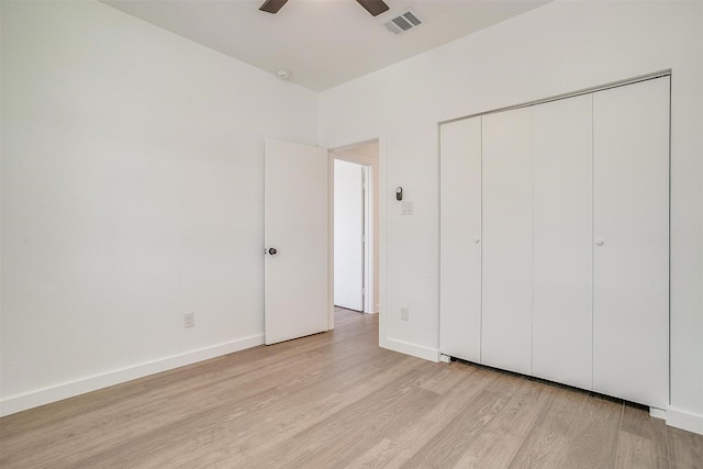 unfurnished bedroom with visible vents, light wood-style flooring, baseboards, and a closet