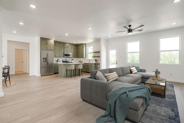 living room featuring recessed lighting, baseboards, a ceiling fan, and light wood finished floors
