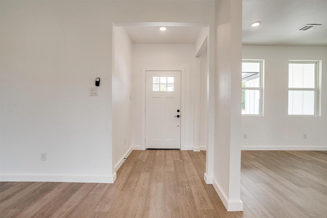 entrance foyer featuring baseboards, light wood finished floors, and visible vents