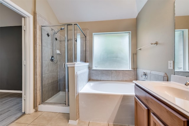 bathroom with a stall shower, a garden tub, tile patterned flooring, and lofted ceiling