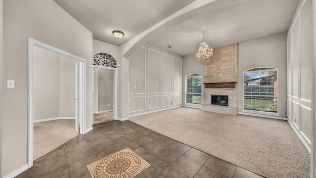 8708 Tangleridge Dr, Fort Worth, TX 76123 - unfurnished living room featuring dark colored carpet, a chandelier, arched walkways, and a large fireplace