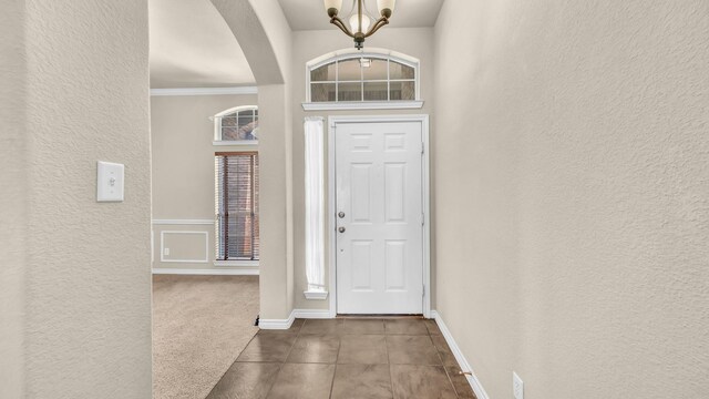 8708 Tangleridge Dr, Fort Worth, TX 76123 - foyer featuring a textured wall, arched walkways, a chandelier, and ornamental molding