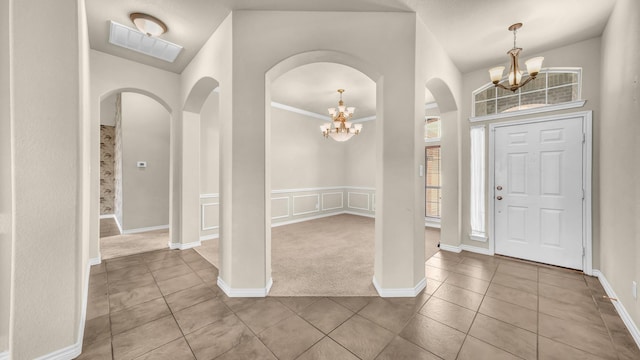 8708 Tangleridge Dr, Fort Worth, TX 76123 - tiled entryway featuring a chandelier, arched walkways, and a wainscoted wall