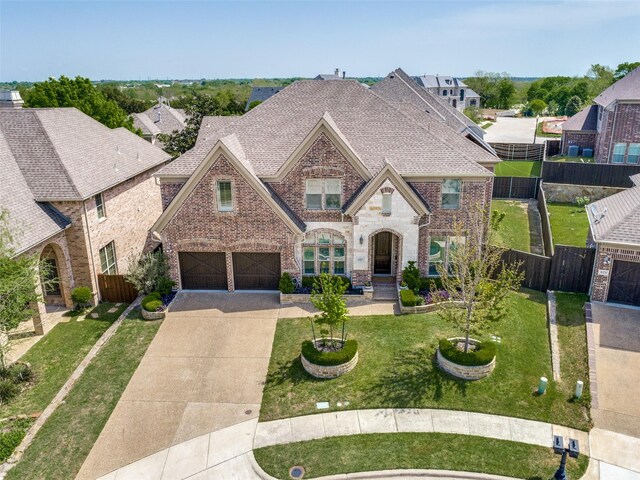 617 Denton Creek Dr, Mckinney, TX 75072 - french country style house featuring a garage, fence, driveway, and brick siding