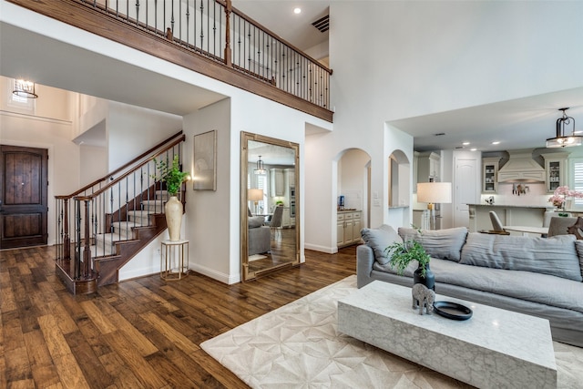 617 Denton Creek Dr, Mckinney, TX 75072 - living room featuring visible vents, stairway, a high ceiling, wood finished floors, and baseboards