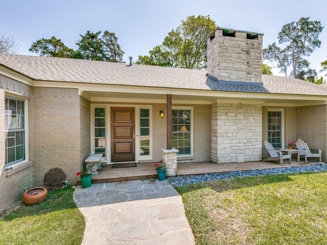 705 W Colorado Blvd, Dallas, TX 75208 - view of exterior entry featuring a chimney, a lawn, covered porch, and brick siding