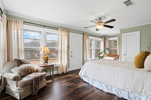 bedroom with crown molding, visible vents, multiple windows, and dark wood finished floors