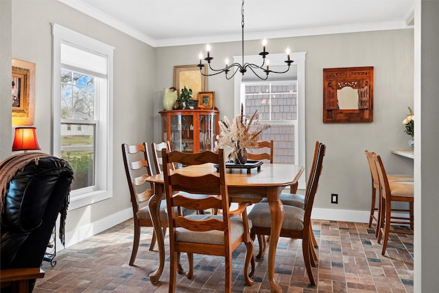 dining room with brick floor, an inviting chandelier, baseboards, and ornamental molding