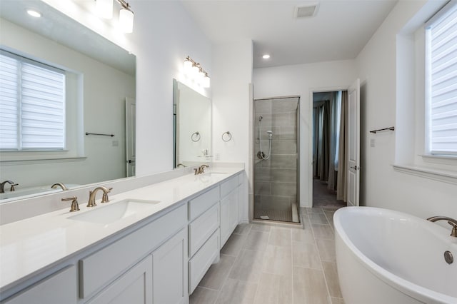 full bath with a sink, visible vents, double vanity, and a stall shower