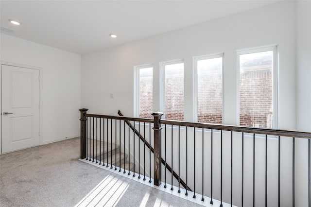 interior space with recessed lighting, an upstairs landing, and carpet