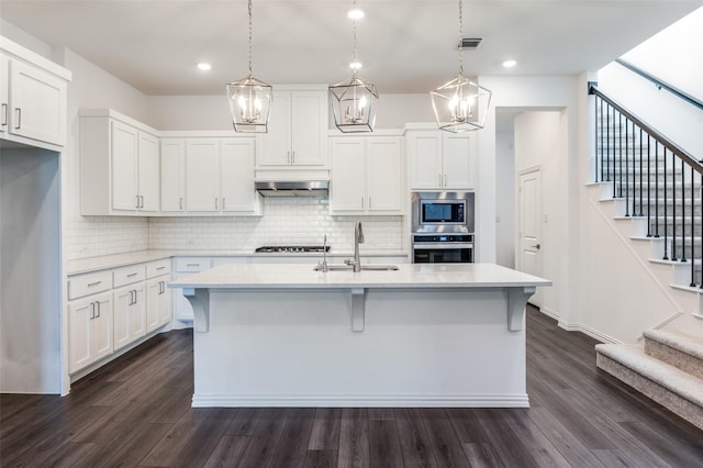 kitchen featuring visible vents, a sink, light countertops, stainless steel appliances, and extractor fan