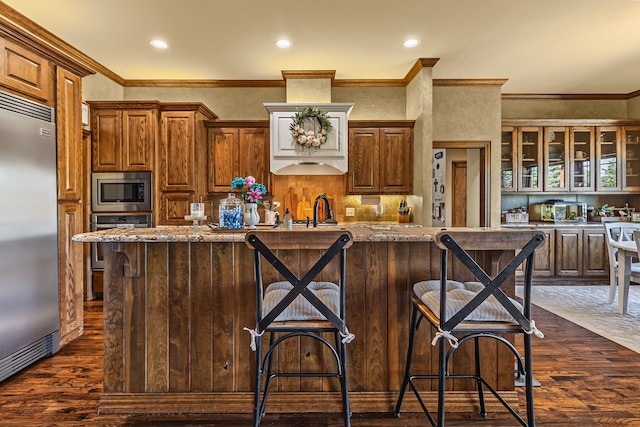 4682 County Road 2720, Caddo Mills, TX 75135 - kitchen with dark wood-type flooring, built in appliances, glass insert cabinets, and a kitchen breakfast bar