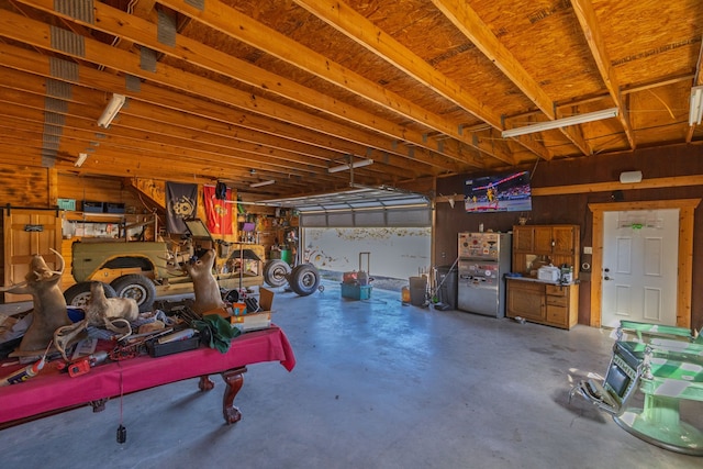 4682 County Road 2720, Caddo Mills, TX 75135 - garage with wooden walls and freestanding refrigerator