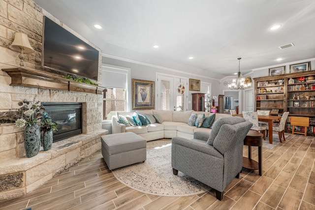 living area with crown molding, visible vents, a chandelier, and wood finished floors