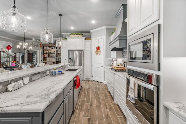 kitchen with stainless steel appliances, gray cabinetry, white cabinets, and a chandelier