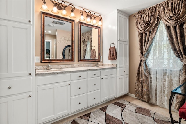 1412 Conejos Ct, Granbury, TX 76048 - bathroom featuring double vanity, tile patterned floors, and a sink