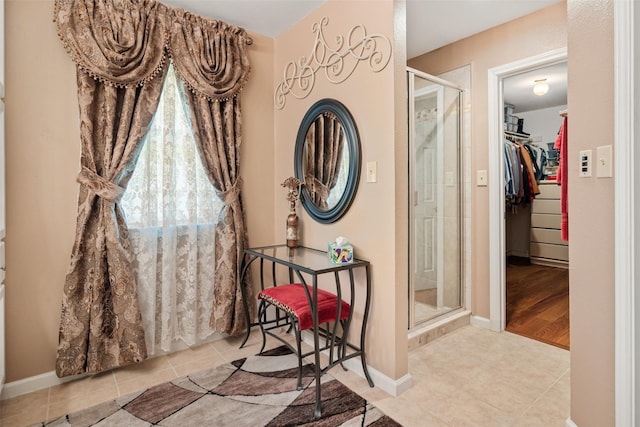 1412 Conejos Ct, Granbury, TX 76048 - interior space featuring baseboards, tile patterned floors, a walk in closet, and a stall shower