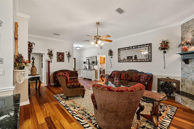 1412 Conejos Ct, Granbury, TX 76048 - living room featuring ceiling fan, a stone fireplace, wood finished floors, visible vents, and ornamental molding