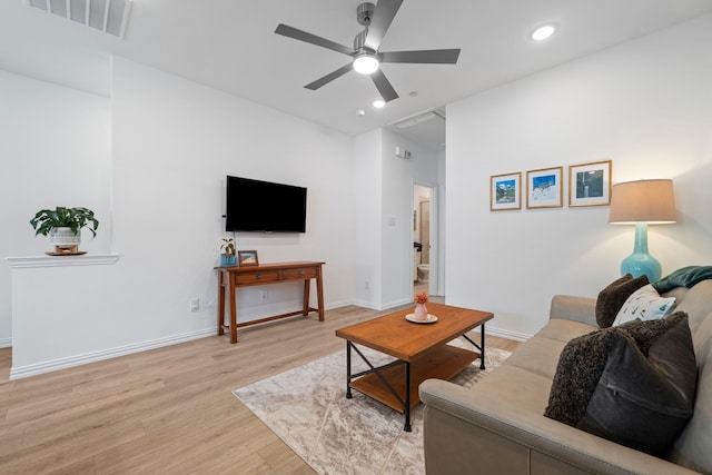 living room with visible vents, baseboards, light wood finished floors, and a ceiling fan