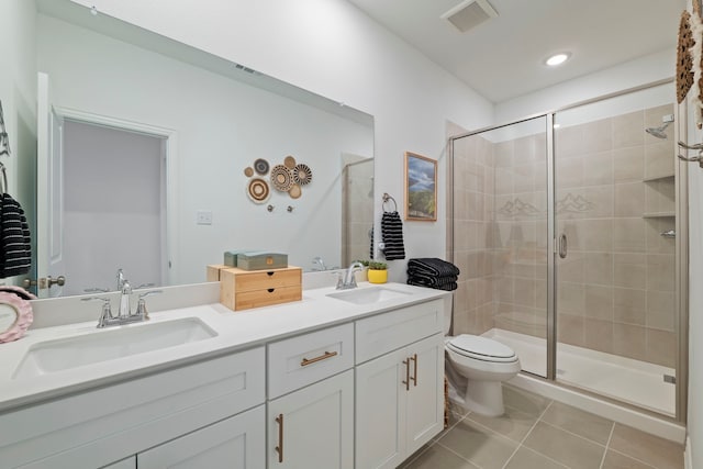 bathroom with a shower stall, tile patterned flooring, visible vents, and a sink
