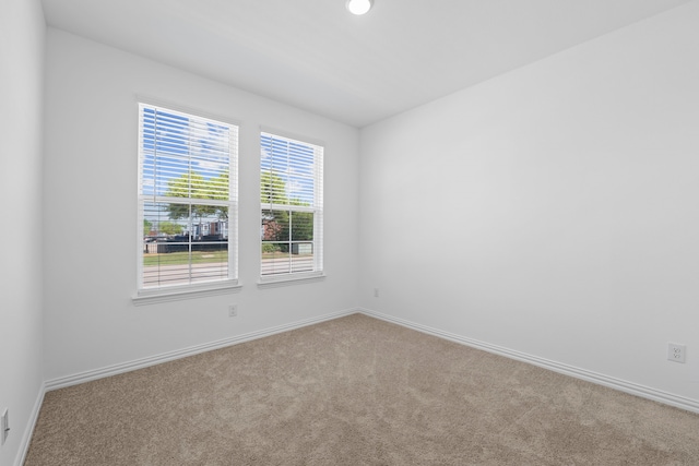 carpeted spare room featuring baseboards