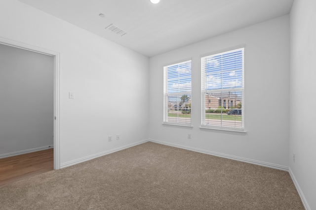 carpeted empty room with baseboards and visible vents