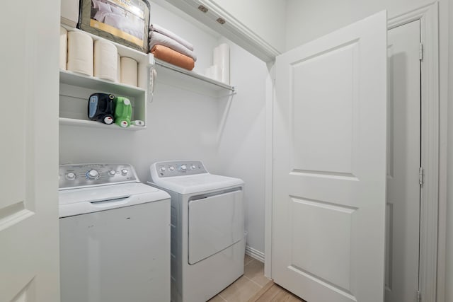 laundry room with light tile patterned floors, washing machine and dryer, and laundry area