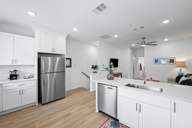 kitchen featuring light wood-type flooring, appliances with stainless steel finishes, a sink, and visible vents