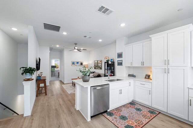 kitchen with a sink, visible vents, light countertops, and dishwasher