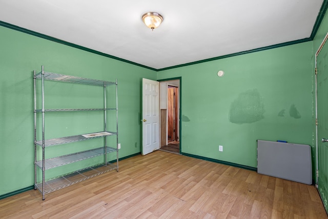 unfurnished bedroom with baseboards, crown molding, and wood finished floors
