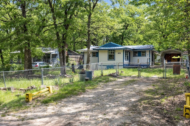 bungalow-style home with metal roof, a gate, and a fenced front yard