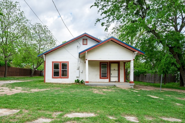 view of front of house featuring a front lawn, fence, and covered porch