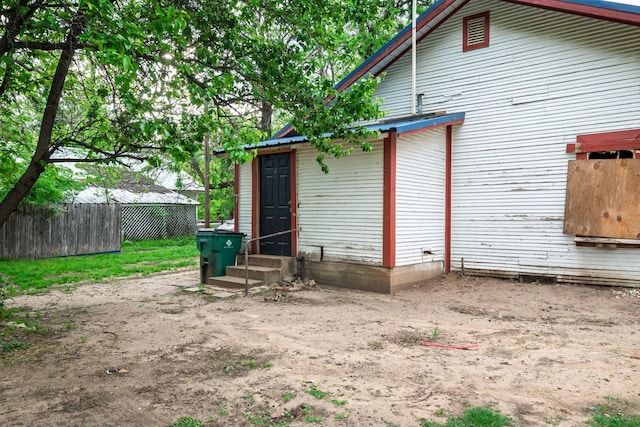 back of property with entry steps and fence