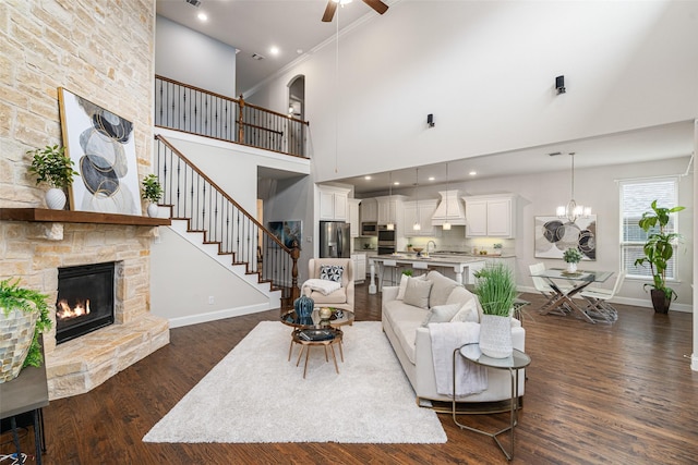 313 Grove Park Pl, Mckinney, TX 75071 - living area with ceiling fan, a fireplace, a high ceiling, dark wood-type flooring, and baseboards